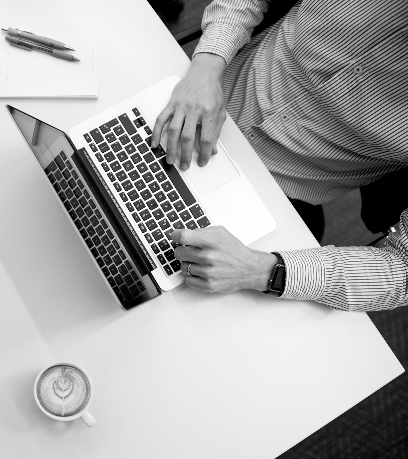 Man foramlly dressed sitting in front of a notebook doing public realtion stuff